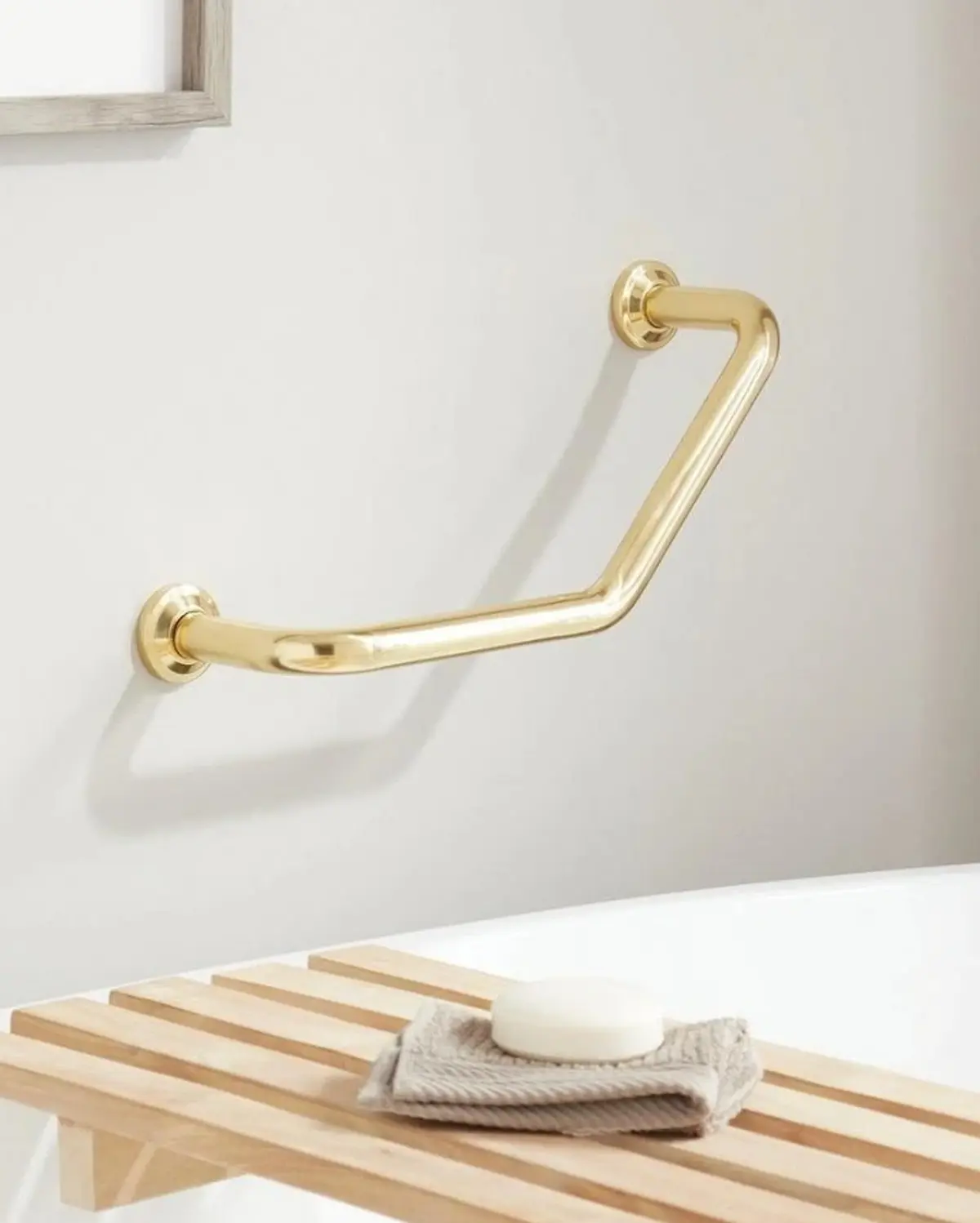 Designer grab bar in a polished finish styled into a refined bathroom setting — by Renata Glaz